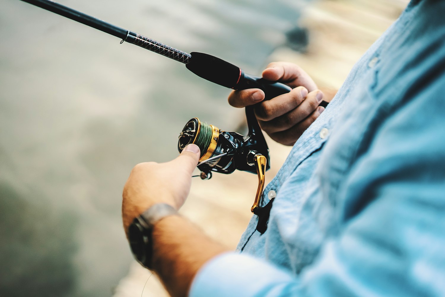 A spinning reel being spooled with fresh line